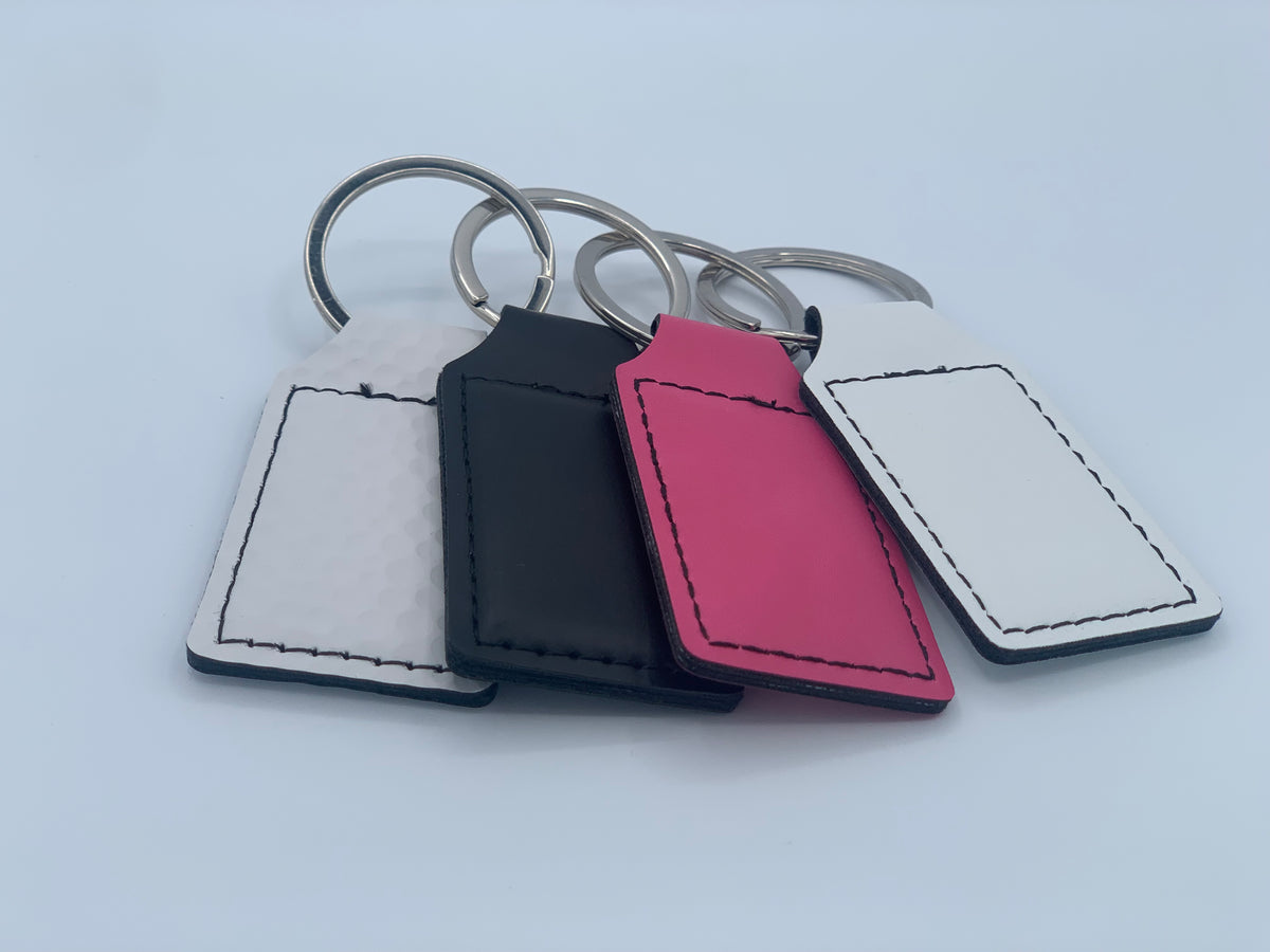 Multiple leatherette keychains shown together to compare available colors and finishes.