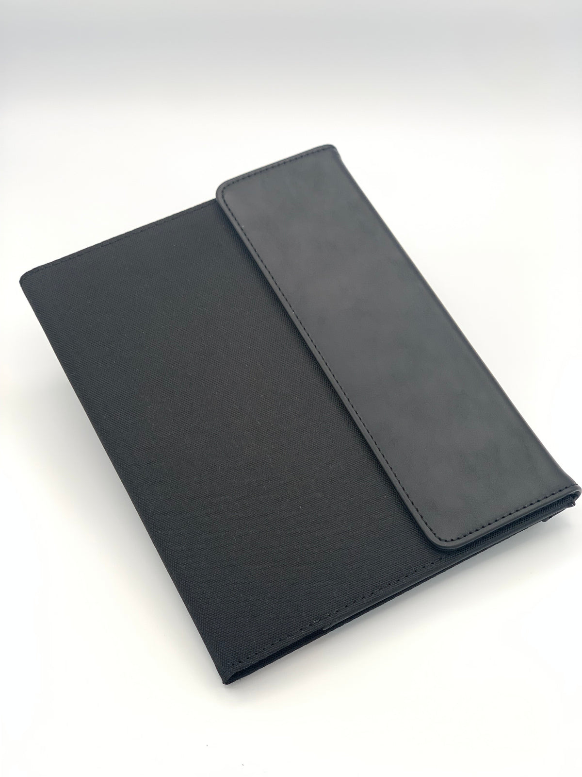 Angled view of the Black/Black leatherette padfolio showing its clean professional exterior and flap detail.