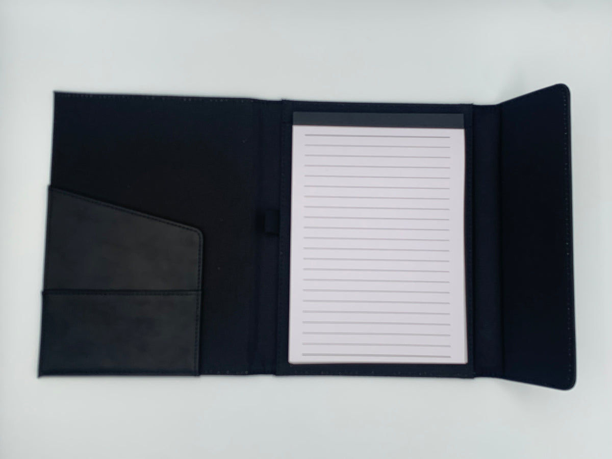 Open Black/Black padfolio showing the refillable lined writing pad, interior pocket, and coordinated two-tone construction.