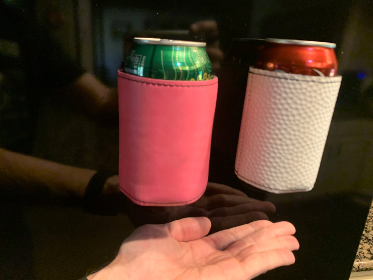 Primrose Pink and White Golf Ball Textured magnetic can coolers attached to a compatible metal surface, demonstrating the hands-free magnetic design.