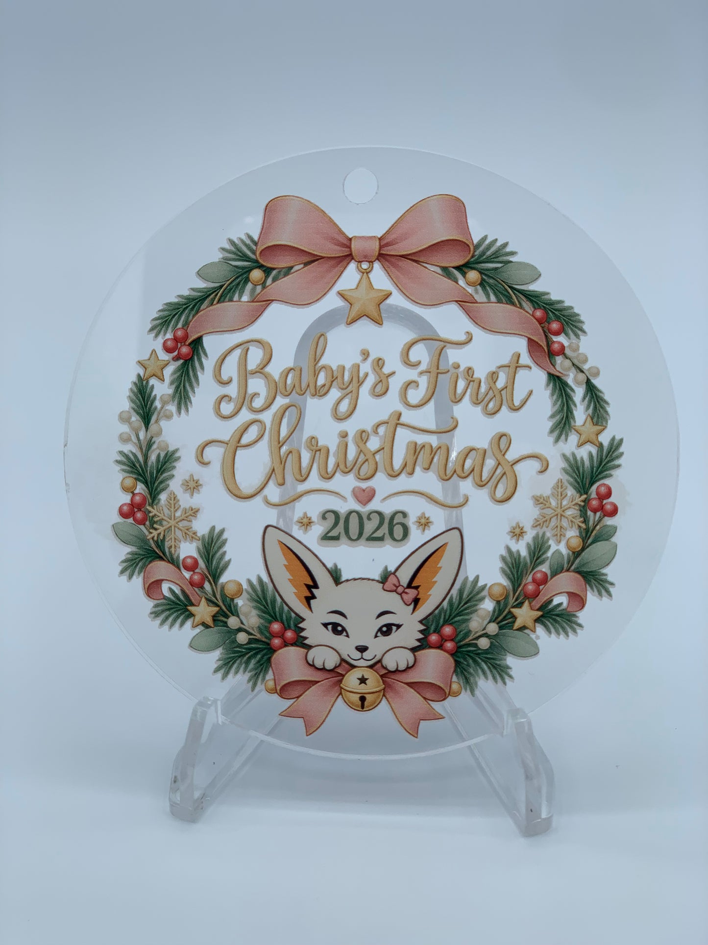 Personalized 3.5" Round acrylic ornament featuring a Baby’s First Christmas 2026 design with festive greenery, pink and gold details, and Fiona the fennec fox.