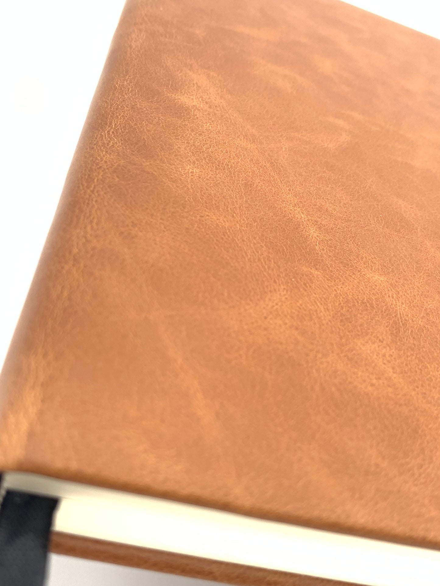 Close-up of the Rawhide leatherette cover showing the material texture, edge construction, and page block.