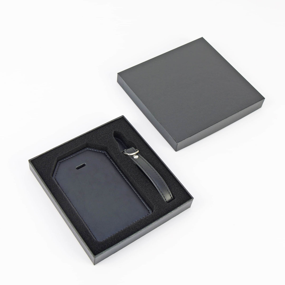 Black leatherette luggage tag presented in its included black gift box with protective foam insert.