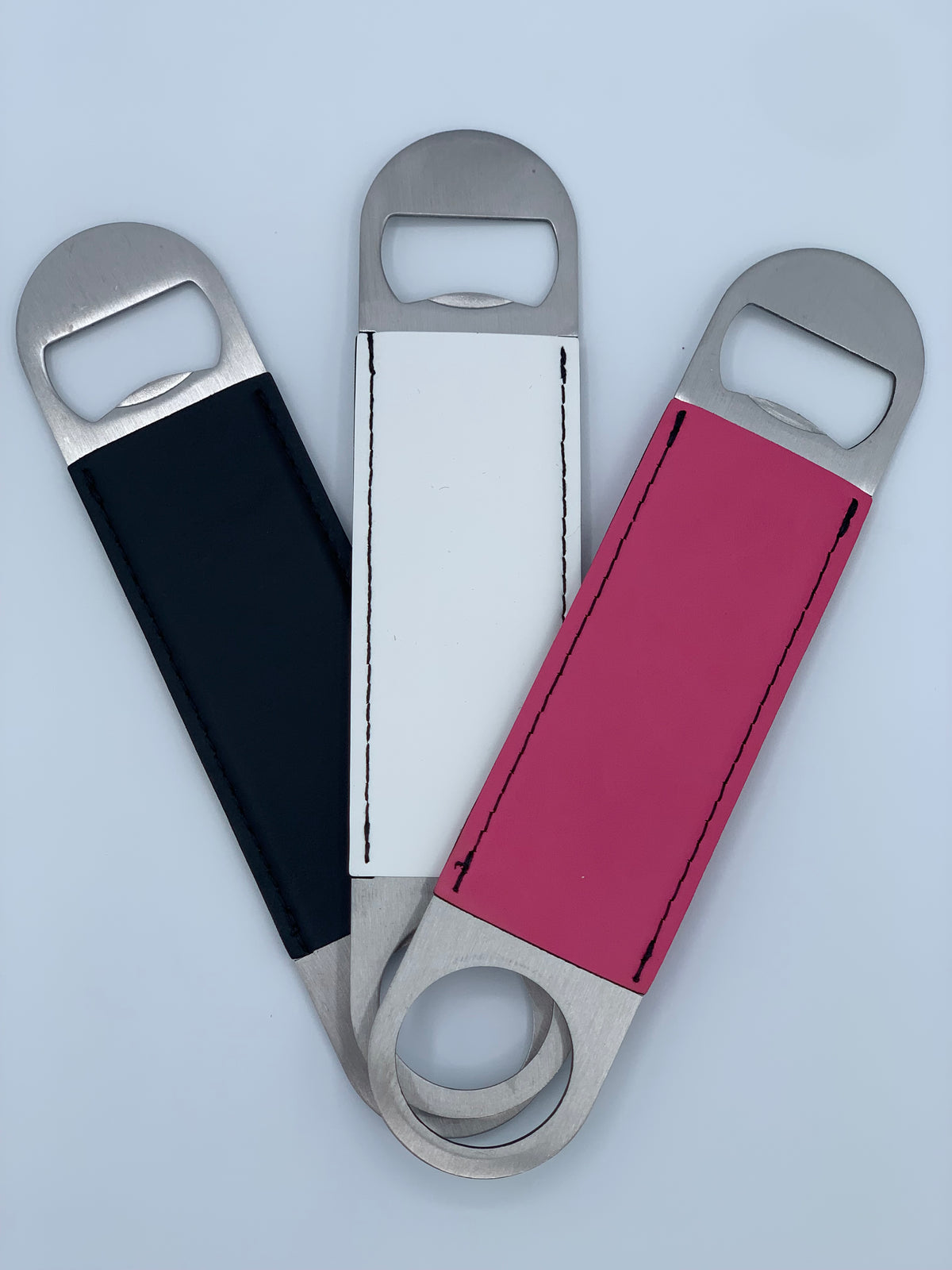 Leatherette bar key bottle openers shown in black, white, and primrose pink color options.