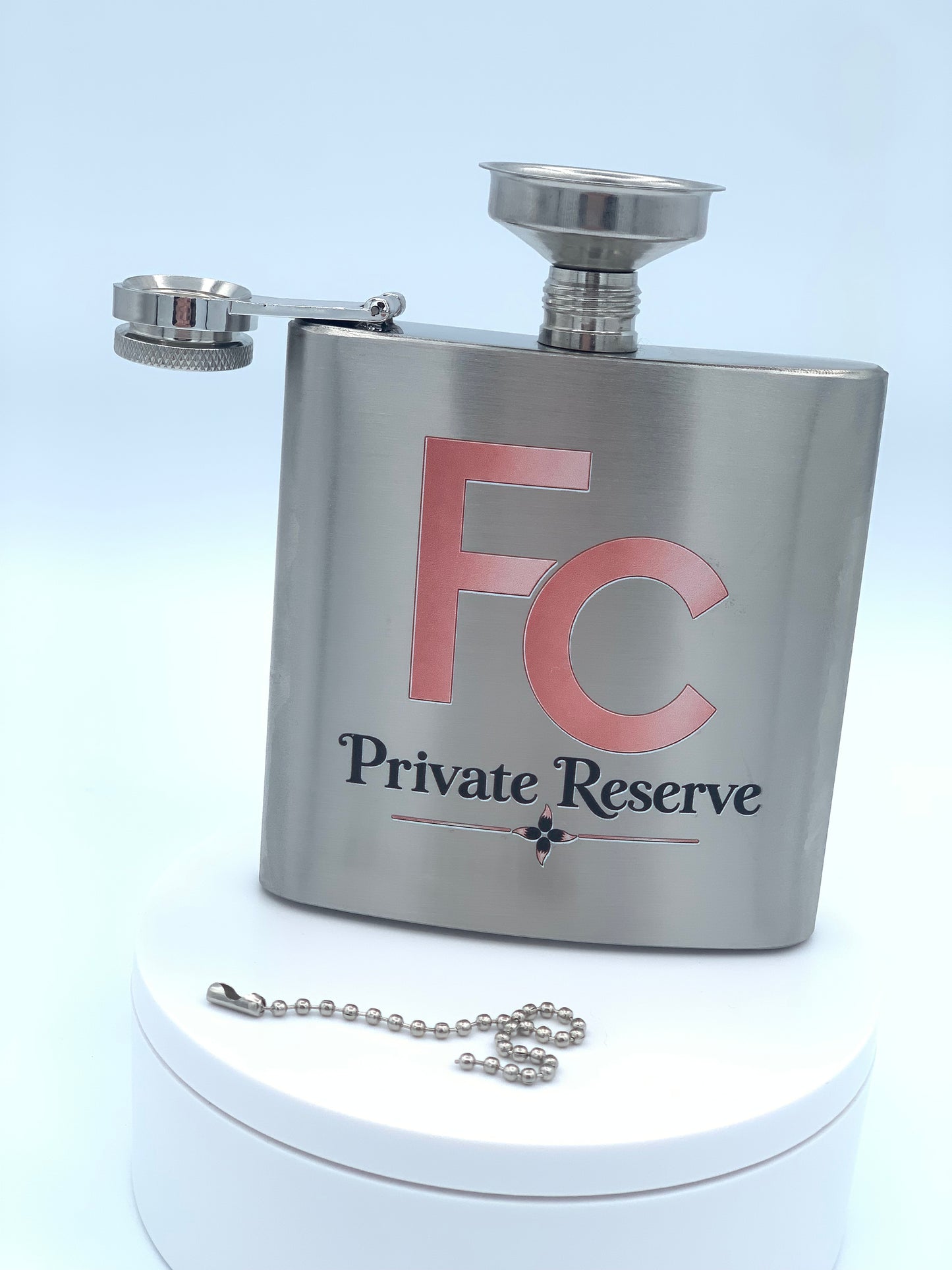 Personalized stainless steel flask with custom artwork, screw-on cap, and attached funnel in filling position.